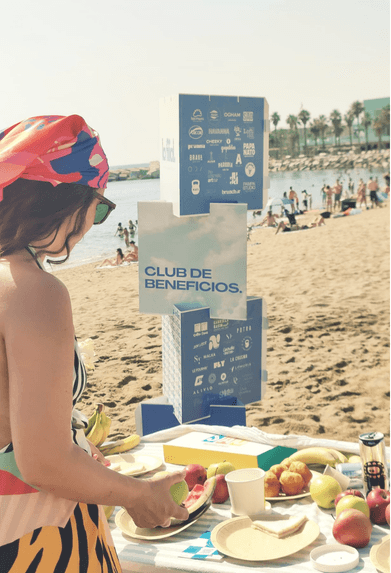 Mesa de La Filial en la playa de Barcelona junto al cartel Club de Beneficios